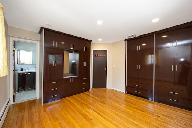 15 Linden St, Great Neck, NY 11021 - unfurnished bedroom featuring a baseboard radiator, light wood-style flooring, a closet, ensuite bath, and recessed lighting