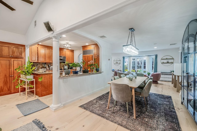 76 Keswick Ln, Plainview, NY 11803 - dining area featuring light wood-style floors, decorative columns, recessed lighting, arched walkways, and vaulted ceiling