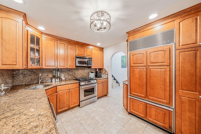 76 Keswick Ln, Plainview, NY 11803 - kitchen with appliances with stainless steel finishes, tasteful backsplash, arched walkways, light tile patterned flooring, and light stone counters