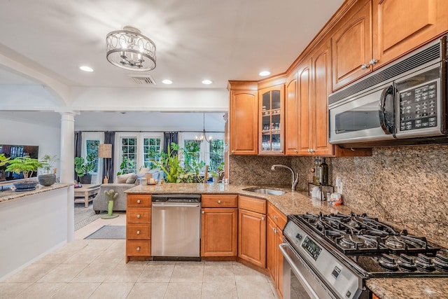 76 Keswick Ln, Plainview, NY 11803 - kitchen featuring stainless steel appliances, a chandelier, brown cabinetry, light stone counters, and recessed lighting