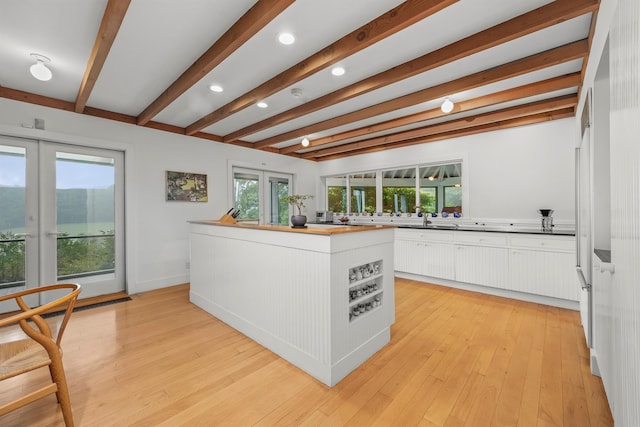 3778 State Route 82, Ancramdale, NY 12503 - kitchen featuring french doors, beamed ceiling, white cabinetry, a center island, and light wood-style floors