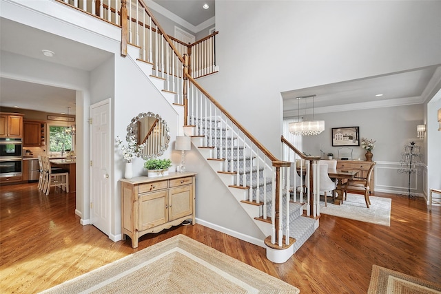 53 Quail Ln, Brewster, NY 10509 - stairway featuring wood finished floors, a high ceiling, crown molding, a chandelier, and recessed lighting