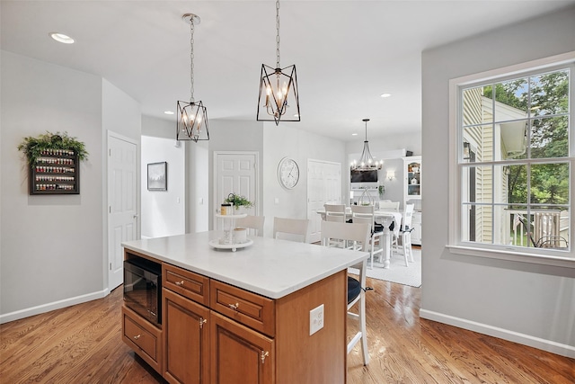 53 Quail Ln, Brewster, NY 10509 - kitchen featuring black microwave, a chandelier, light wood-style floors, a kitchen bar, and recessed lighting