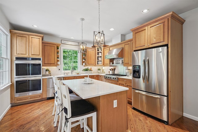 53 Quail Ln, Brewster, NY 10509 - kitchen featuring appliances with stainless steel finishes, wall chimney range hood, a chandelier, tasteful backsplash, and light countertops