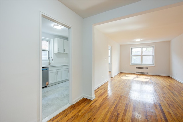 34-15 74th St Unit 5K, Jackson Heights, NY 11372 - spare room featuring radiator, plenty of natural light, and light wood finished floors