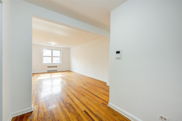 34-15 74th St Unit 5K, Jackson Heights, NY 11372 - empty room with radiator heating unit and hardwood / wood-style floors