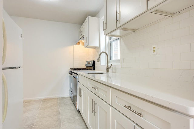 34-15 74th St Unit 5K, Jackson Heights, NY 11372 - kitchen featuring freestanding refrigerator, backsplash, light stone counters, and white cabinets