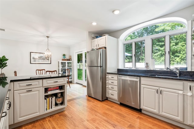 15 Chambers Ct, Huntington Station, NY 11746 - kitchen featuring stainless steel appliances, healthy amount of natural light, white cabinets, a chandelier, and crown molding