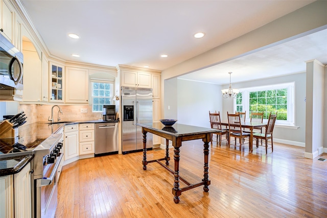 14 Flower Hill Rd, Poughkeepsie, NY 12603 - kitchen with high quality appliances, light wood-style floors, tasteful backsplash, glass insert cabinets, and a chandelier