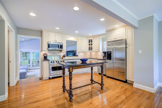 14 Flower Hill Rd, Poughkeepsie, NY 12603 - kitchen featuring premium appliances, light wood-style floors, decorative backsplash, crown molding, and glass insert cabinets