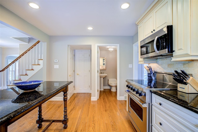 14 Flower Hill Rd, Poughkeepsie, NY 12603 - kitchen with stainless steel appliances, light wood-style floors, decorative backsplash, dark stone countertops, and recessed lighting