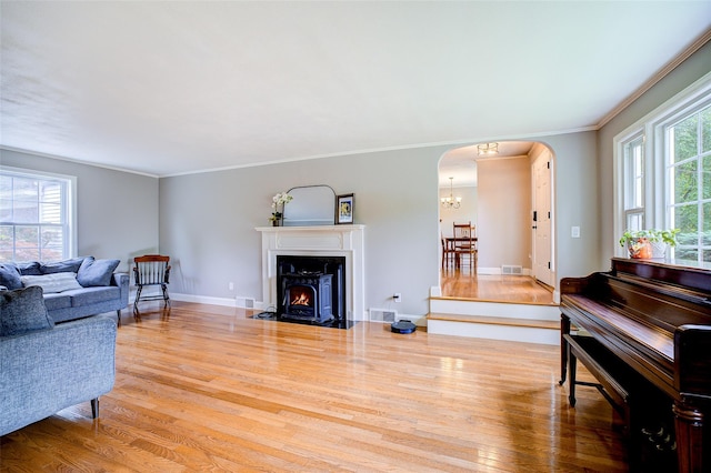 14 Flower Hill Rd, Poughkeepsie, NY 12603 - living area with arched walkways, wood finished floors, a chandelier, crown molding, and a fireplace with flush hearth