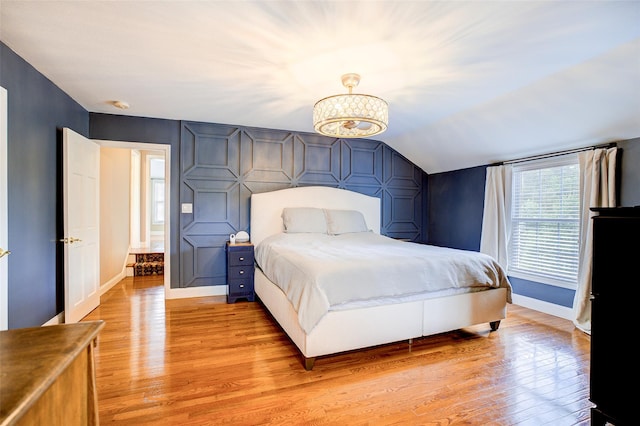 14 Flower Hill Rd, Poughkeepsie, NY 12603 - bedroom featuring light wood-style flooring, lofted ceiling, a chandelier, and an accent wall