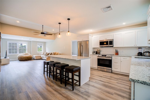 14 Flower Hill Rd, Poughkeepsie, NY 12603 - kitchen with stainless steel appliances, light wood-style flooring, a breakfast bar area, a ceiling fan, and recessed lighting