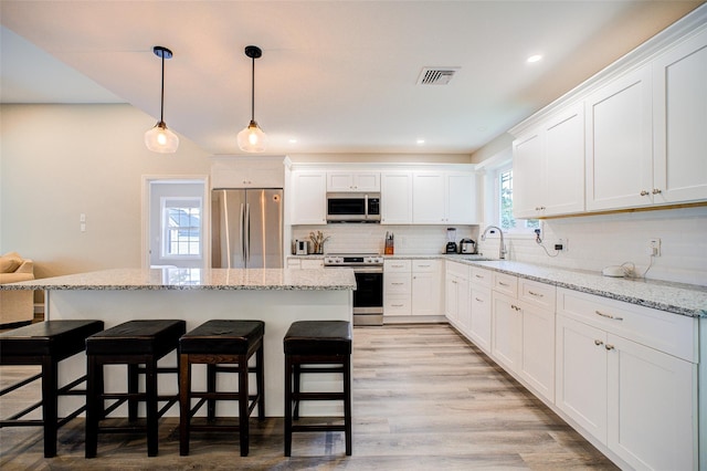 14 Flower Hill Rd, Poughkeepsie, NY 12603 - kitchen featuring appliances with stainless steel finishes, a breakfast bar, white cabinetry, decorative backsplash, and recessed lighting