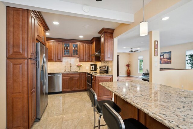 11 Sunrise St, Plainview, NY 11803 - kitchen with stainless steel appliances, brown cabinets, backsplash, a breakfast bar area, and recessed lighting