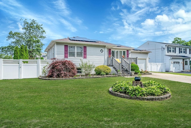43 Ranch Dr, Shirley, NY 11967 - view of front of home with roof mounted solar panels, concrete driveway, an attached garage, and a gate