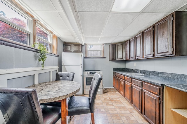 43 Ranch Dr, Shirley, NY 11967 - kitchen featuring stove, freestanding refrigerator, dark countertops, plenty of natural light, and a paneled ceiling