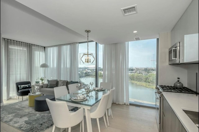 131-01 40th Rd Unit 11N, Flushing, NY 11354 - dining room with a chandelier, a water view, expansive windows, and light wood-style floors