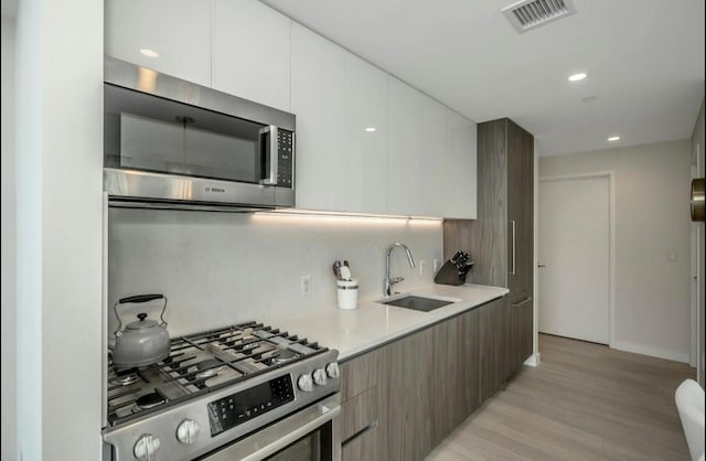 131-01 40th Rd Unit 11N, Flushing, NY 11354 - kitchen featuring appliances with stainless steel finishes, modern cabinets, light wood-style flooring, light countertops, and recessed lighting
