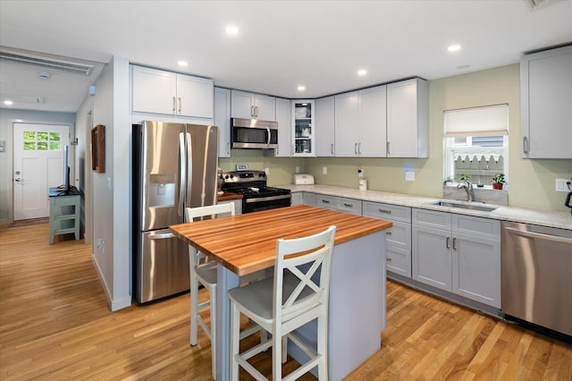 3 Preston Pl, Patterson, NY 12563 - kitchen featuring appliances with stainless steel finishes, wood counters, light wood-type flooring, a kitchen breakfast bar, and glass insert cabinets