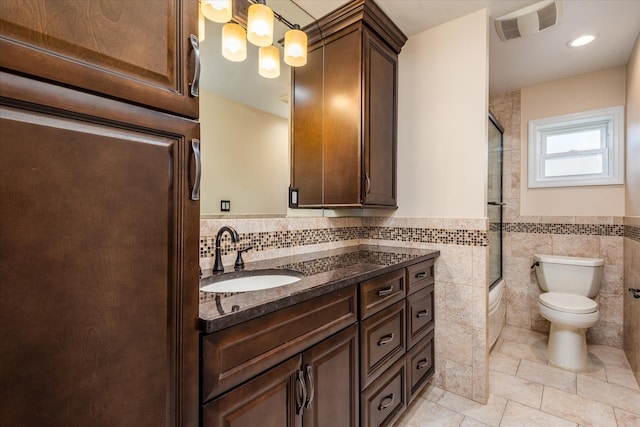 160-46 84th St, Howard Beach, NY 11414 - full bathroom with vanity, tile walls, combined bath / shower with glass door, a wainscoted wall, and tile patterned flooring