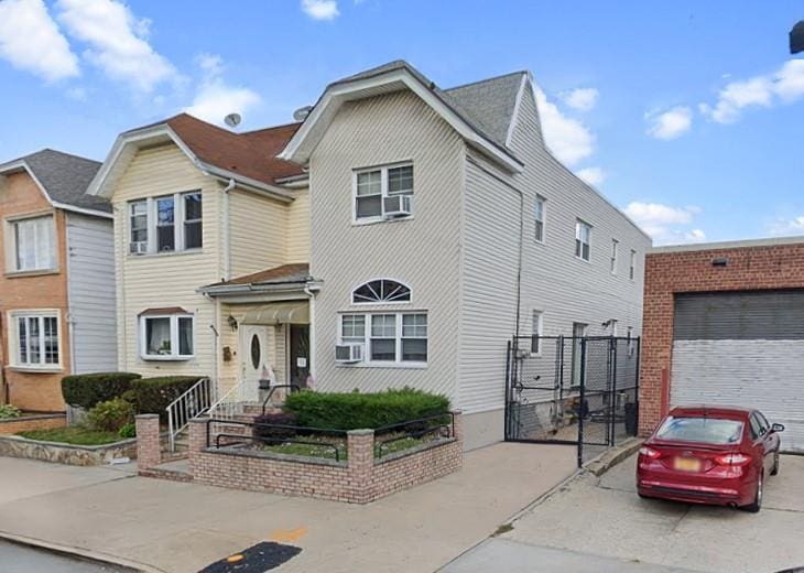 69-55 78th St, Middle Village, NY 11379 - traditional-style house featuring a garage, a gate, and driveway