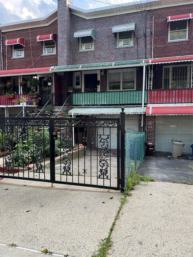 4153 Bruner Ave, Bronx, NY 10466 - traditional-style home featuring brick siding, a garage, a fenced front yard, and asphalt driveway