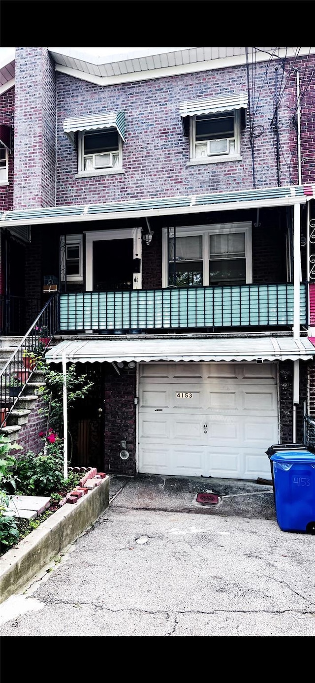 4153 Bruner Ave, Bronx, NY 10466 - view of front of house featuring a garage, brick siding, and asphalt driveway