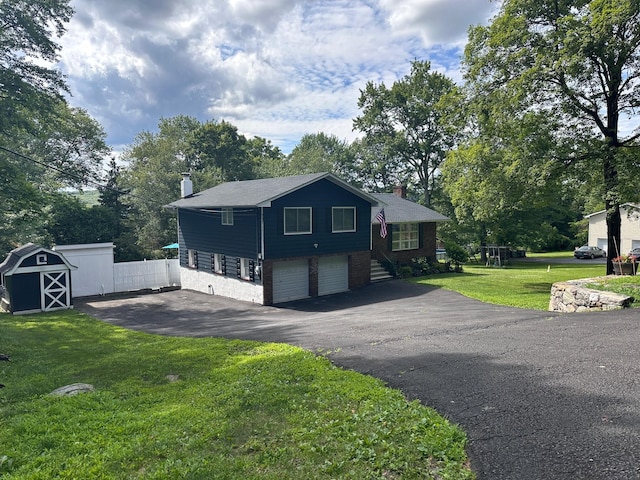 27 W Ave, Putnam Valley, NY 10579 - view of front facade with a chimney, asphalt driveway, an attached garage, and a front yard