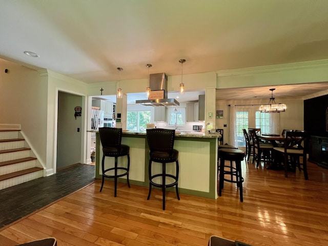 27 W Ave, Putnam Valley, NY 10579 - kitchen with extractor fan, ornamental molding, a kitchen bar, light wood finished floors, and a chandelier
