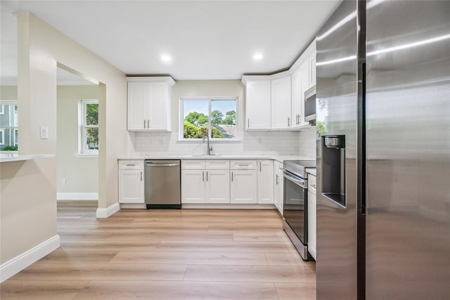 365 Seabreeze Ct, Moriches, NY 11955 - kitchen with appliances with stainless steel finishes, light wood-type flooring, white cabinetry, backsplash, and recessed lighting