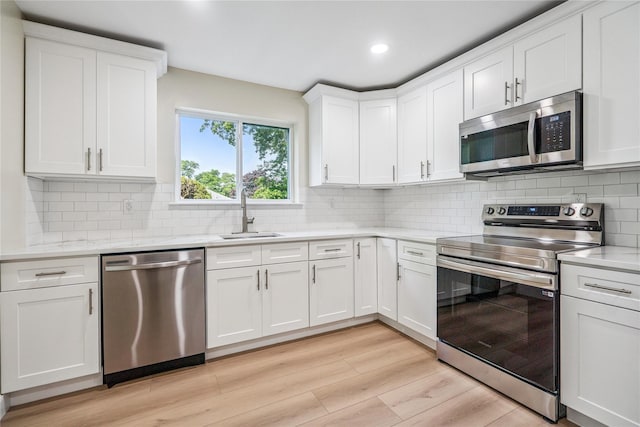 365 Seabreeze Ct, Moriches, NY 11955 - kitchen featuring stainless steel appliances, white cabinets, light wood-style floors, backsplash, and recessed lighting