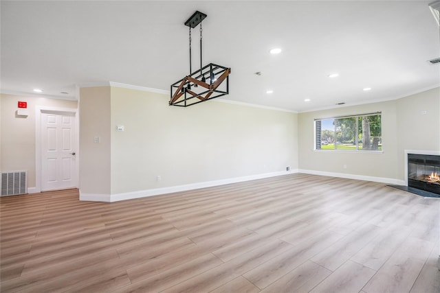 365 Seabreeze Ct, Moriches, NY 11955 - unfurnished living room featuring crown molding, light wood-style flooring, a glass covered fireplace, and recessed lighting
