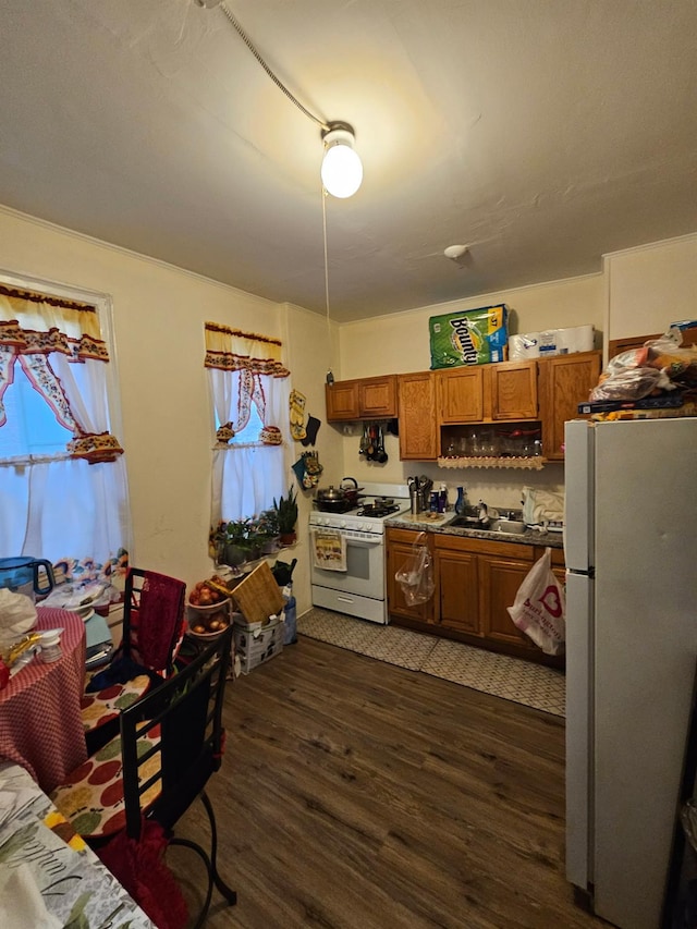 4439 Carpenter Ave, Bronx, NY 10470 - kitchen with white appliances, brown cabinetry, dark wood-style flooring, and healthy amount of natural light