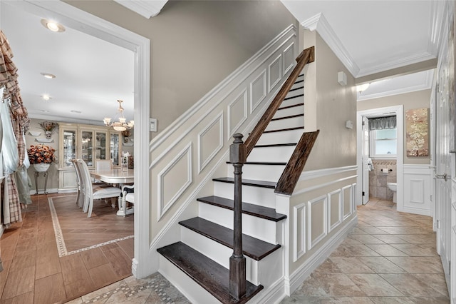 28 Lapin Ln, Blauvelt, NY 10913 - stairway with ornamental molding, a decorative wall, a chandelier, and a wainscoted wall