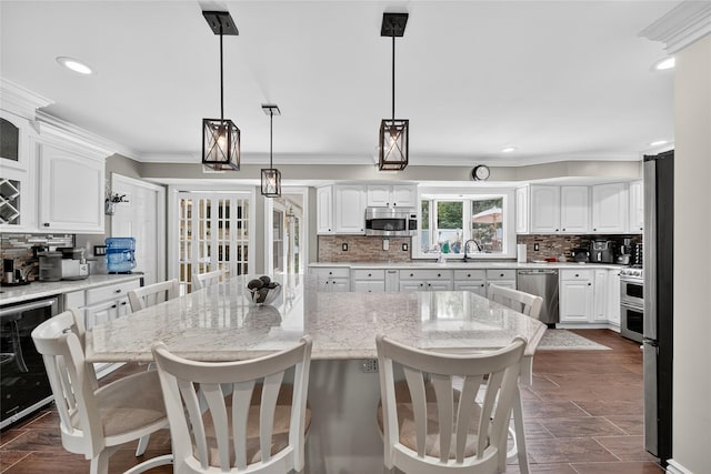 28 Lapin Ln, Blauvelt, NY 10913 - kitchen with stainless steel appliances, crown molding, a kitchen breakfast bar, backsplash, and white cabinets