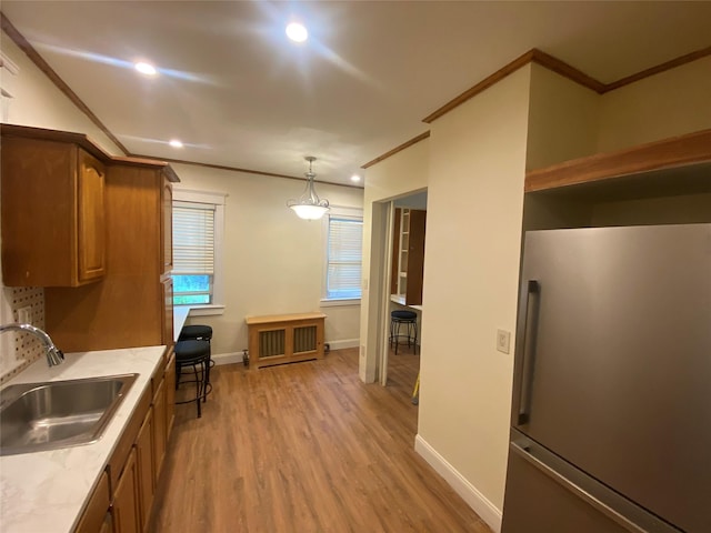 15 Grant St, Yonkers, NY 10704 - kitchen featuring high quality fridge, brown cabinets, crown molding, light wood finished floors, and light countertops