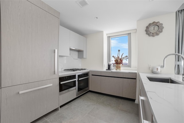 133-36 37th Ave Unit 10, Flushing, NY 11354 - kitchen featuring light stone counters, appliances with stainless steel finishes, light tile patterned floors, and exhaust hood