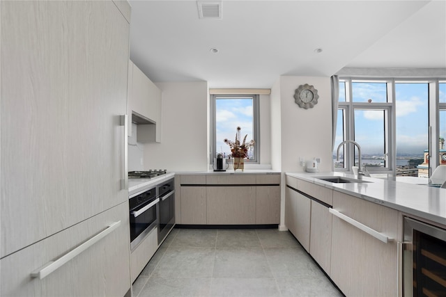 133-36 37th Ave Unit 10, Flushing, NY 11354 - kitchen featuring wine cooler, light countertops, stainless steel appliances, and light tile patterned floors
