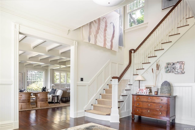 12120 New Suffolk Ave, Cutchogue, NY 11935 - stairway with a decorative wall, beam ceiling, wainscoting, and wood finished floors