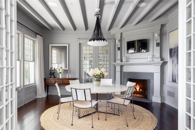 12120 New Suffolk Ave, Cutchogue, NY 11935 - dining area with dark wood-style flooring, beamed ceiling, a fireplace with flush hearth, and crown molding