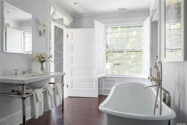 12120 New Suffolk Ave, Cutchogue, NY 11935 - bathroom featuring wood finished floors, a freestanding tub, and crown molding