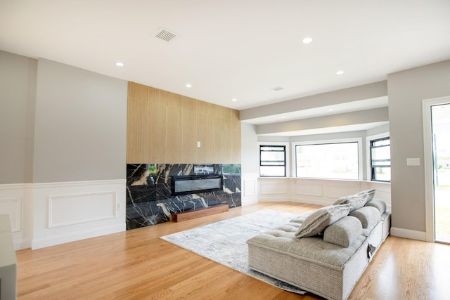 38 Bradford Ln, Bethpage, NY 11714 - living room featuring a decorative wall, a high end fireplace, recessed lighting, light wood finished floors, and a wainscoted wall