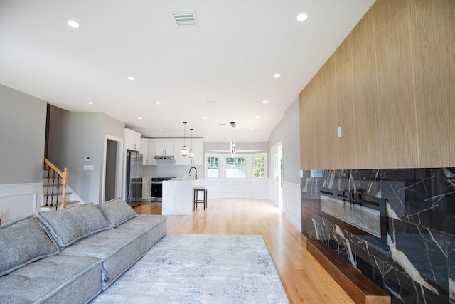 38 Bradford Ln, Bethpage, NY 11714 - living room with light wood finished floors, wainscoting, recessed lighting, stairs, and a decorative wall