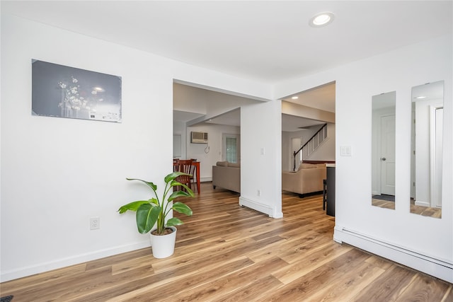 406 Red Maple Dr W, Wantagh, NY 11793 - empty room with a baseboard heating unit, stairs, light wood-type flooring, recessed lighting, and a wall mounted AC