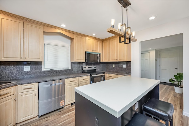 406 Red Maple Dr W, Wantagh, NY 11793 - kitchen featuring stainless steel appliances, a breakfast bar area, light brown cabinets, light wood finished floors, and a center island