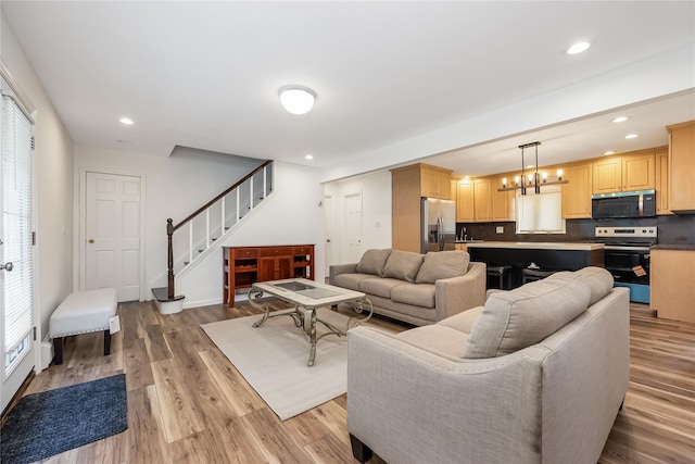 406 Red Maple Dr W, Wantagh, NY 11793 - living area featuring light wood finished floors, stairway, recessed lighting, healthy amount of natural light, and a chandelier