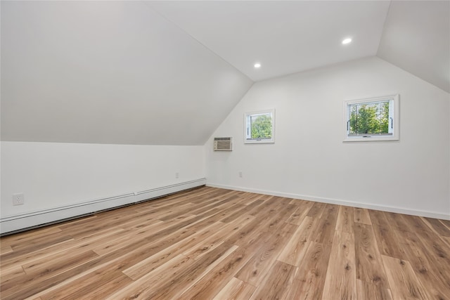 406 Red Maple Dr W, Wantagh, NY 11793 - bonus room featuring baseboard heating, lofted ceiling, healthy amount of natural light, a wall mounted air conditioner, and light wood-style floors