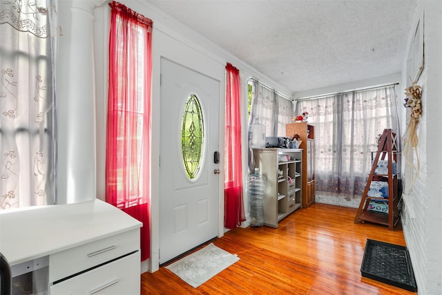 110 Pine Ave, Ossining, NY 10562 - foyer entrance with light wood-type flooring, a textured ceiling, and crown molding